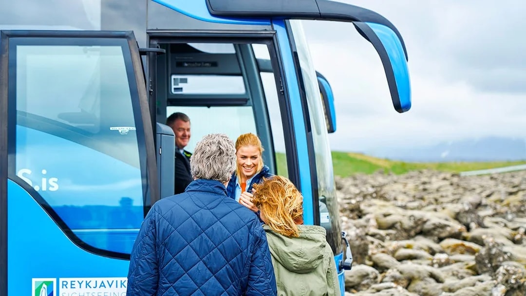 Tourists boarding Reykjavik Sightseeing transfer bus in Iceland.