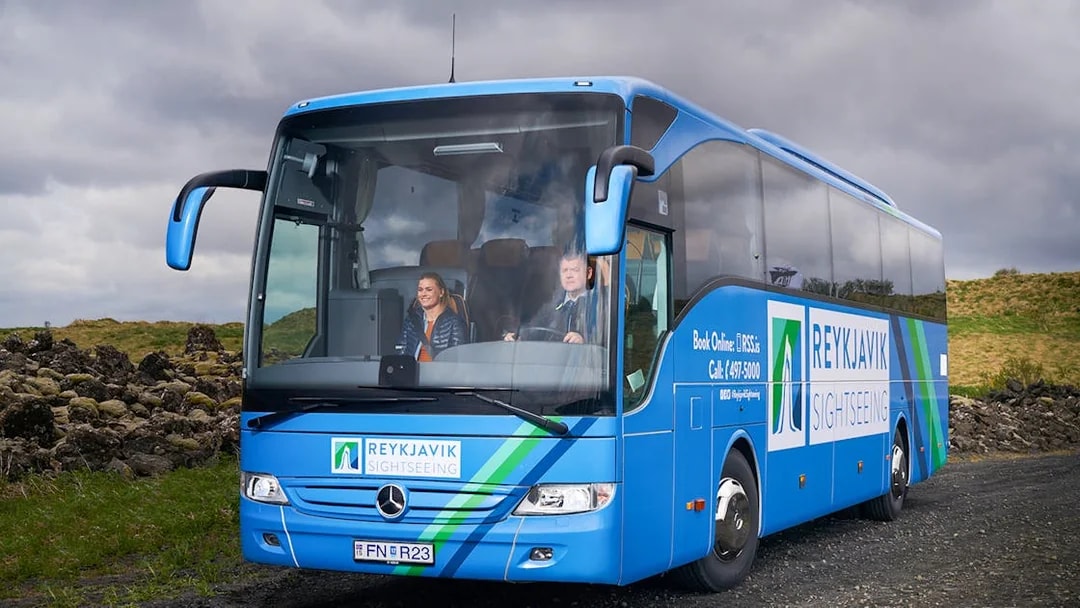 Reykjavik sightseeing bus on Golden Circle tour route with passengers.
