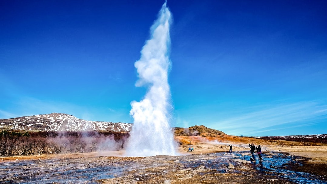 Geyser erupting in Icelandic landscape on Golden Circle tour from Reykjavik.