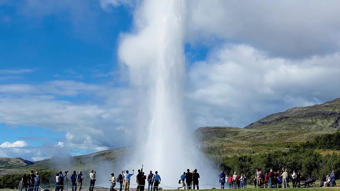Tourists watching Geysir erupt during Golden Circle day trip in Iceland.