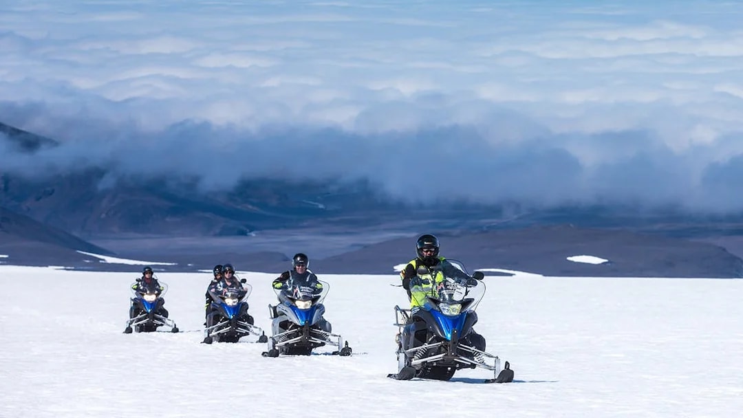 Snowmobile group riding on Langjokull Glacier, Iceland.