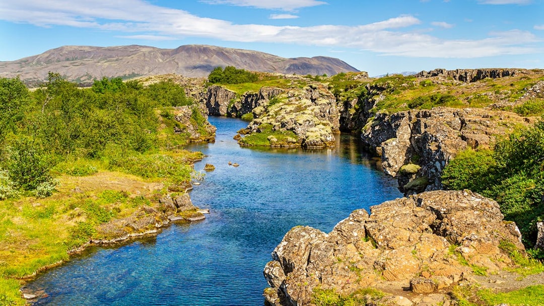 Rocky cliffs and lush greenery at Thingvellir National Park, Iceland.