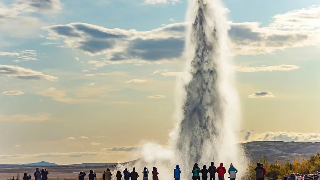 Tourists watching Strokkur geyser erupt in Iceland's Golden Circle.