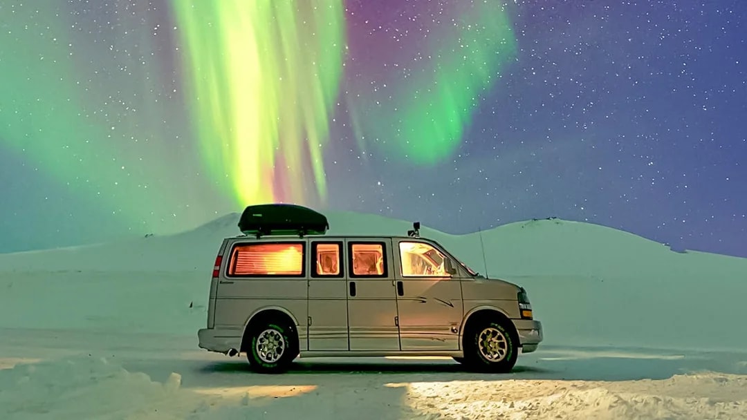 Minivan under Northern Lights during premium small group tour.