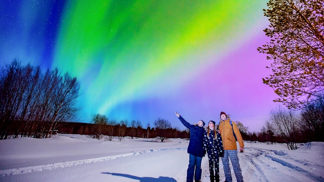 Tourists enjoying Northern Lights at Blue Lagoon geothermal spa, Iceland.