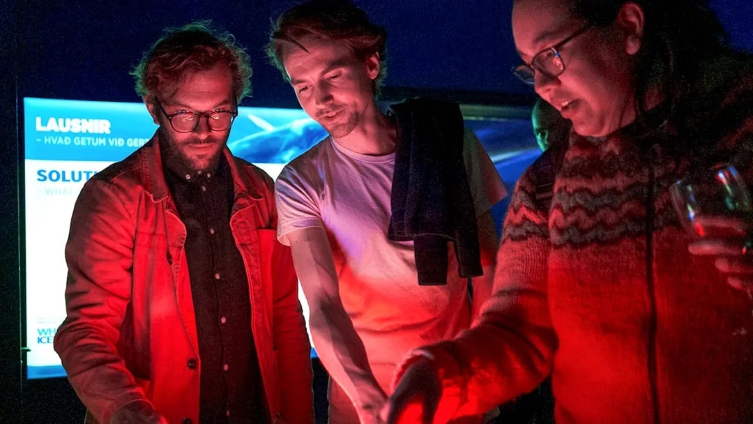 People interacting with a digital display on a Northern Lights cruise from Reykjavik.