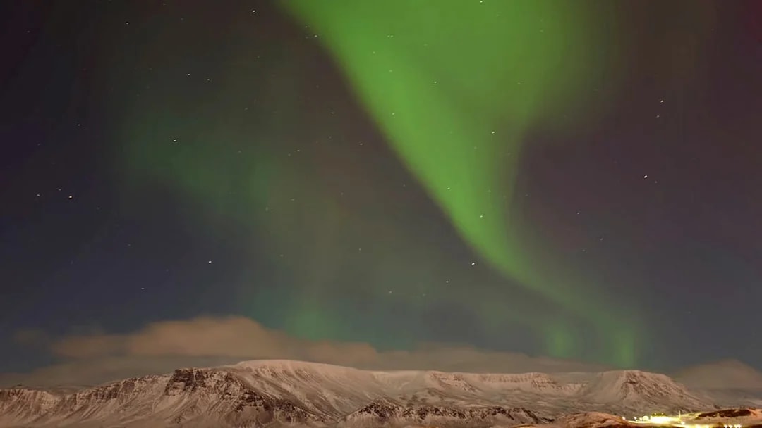 Northern Lights over snowy mountains near Reykjavik, Iceland.