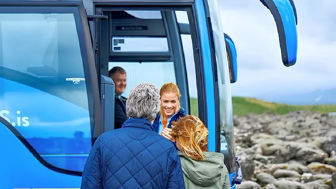 Visitors boarding a blue tour bus for Sky Lagoon in Reykjavik, Iceland.