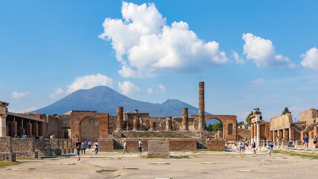 Temple of Giove ruins in Pompeii with Mount Vesuvius in the background.
