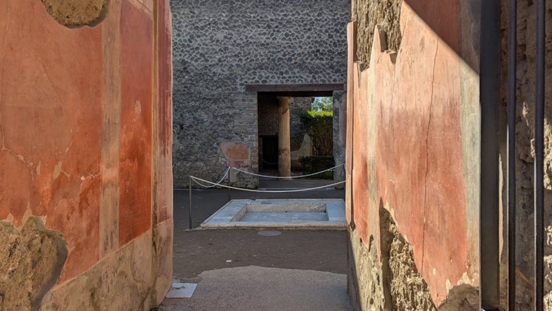 Ancient frescoed walls and courtyard in the ruins of Pompeii, Italy.