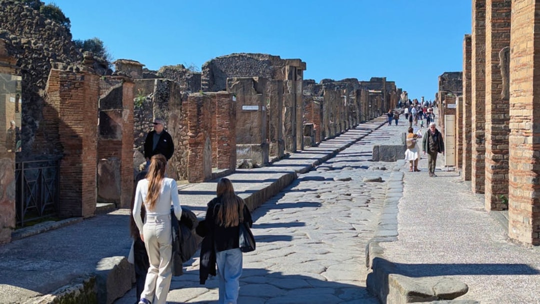 Visitors walking along the ancient cobblestone streets of Pompeii, Italy.