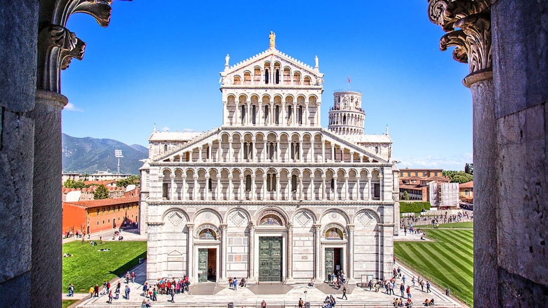 Primate Metropolitan Cathedral of Santa Maria Assunta in Pisa with tourists in the foreground.