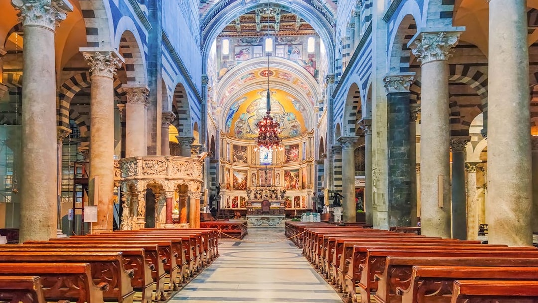 Interior of Pisa Cathedral with ornate columns and detailed frescoes, part of the Florence and Pisa tour.
