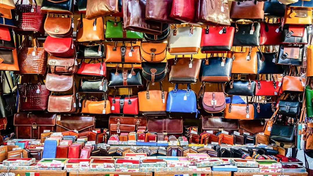 Leather bags and wallets displayed at a market stall in Florence, Italy.