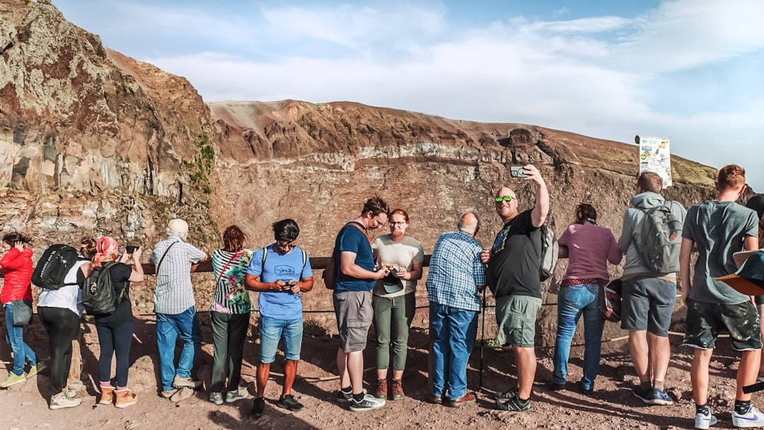 Tourists taking photos at the crater of Mount Vesuvius, Italy.