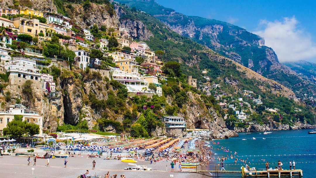 Positano's La Scogliera Beach with colorful umbrellas, part of Rome to Pompeii and Mount Vesuvius tour.
