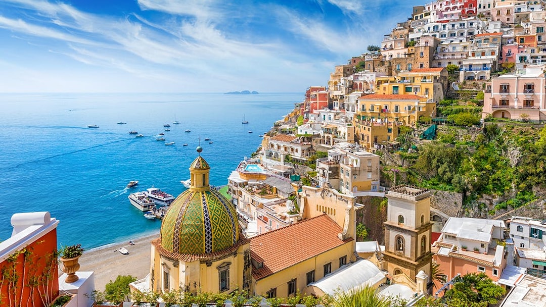 Positano village on the Amalfi Coast with colorful cliffside houses and boats on the sea.