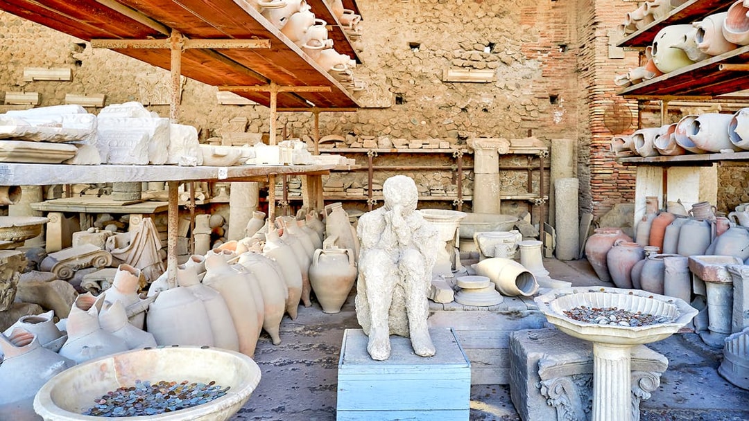Ancient artifacts and plaster cast in Pompeii marketplace.