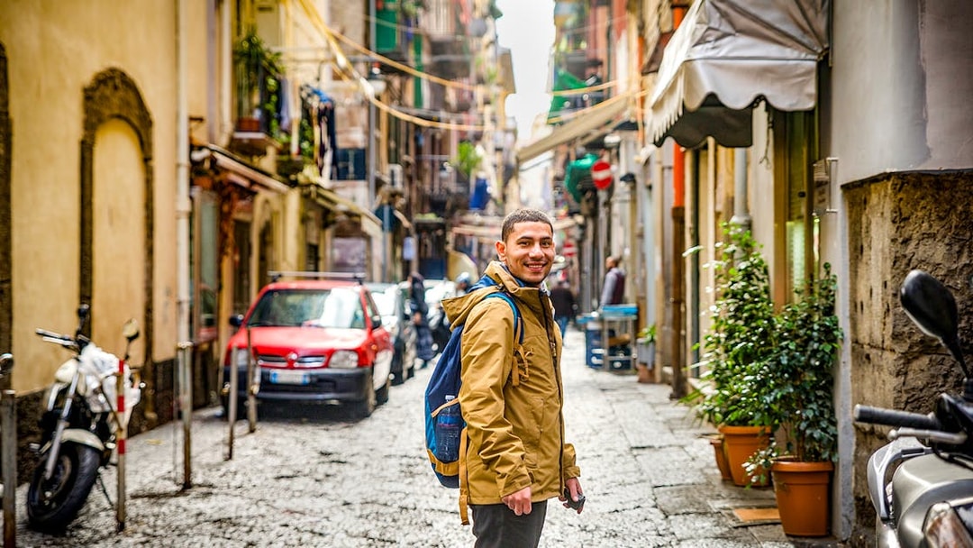Traveler exploring a narrow street in Naples, Italy.