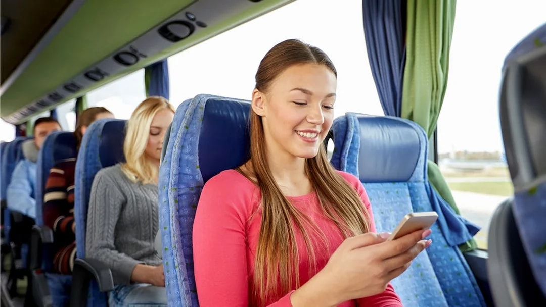 Passenger using phone inside a tour bus.