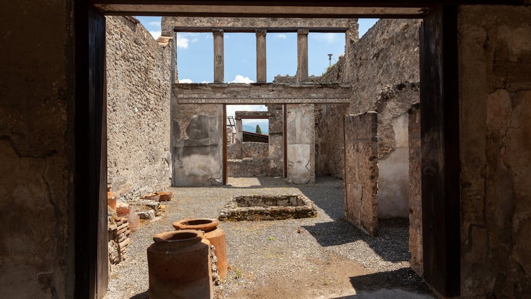 Pompeii ruins with ancient stone walls and pottery, viewed by tourists on a Rome day trip.