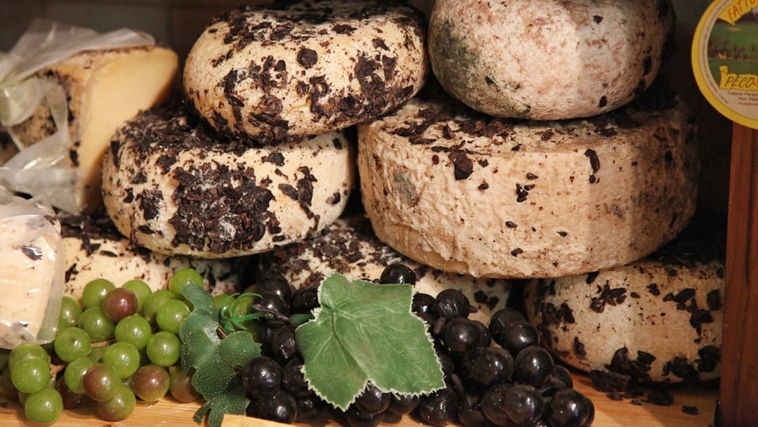 Cheese wheels with truffles and grapes, Tuscany tour highlight.