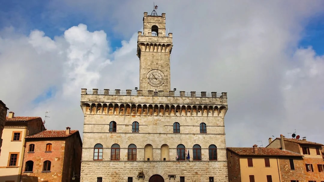 Palazzo Comunale in Montepulciano, Tuscany, Italy, under a cloudy sky.