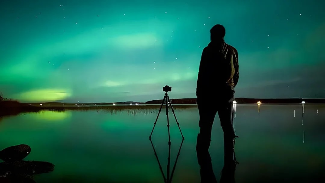 Photographer capturing Northern Lights in Rovaniemi on a guided tour.
