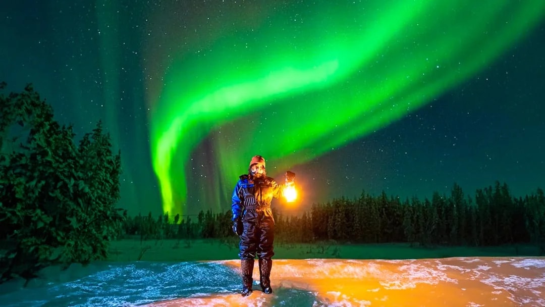 Guest photographing Northern Lights on Aurora expedition in Rovaniemi, Finland.