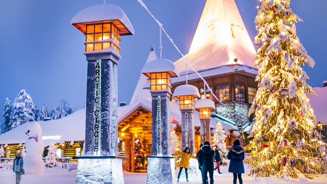 Santa Claus Village entrance with snow-covered pillars and Christmas tree, Rovaniemi.