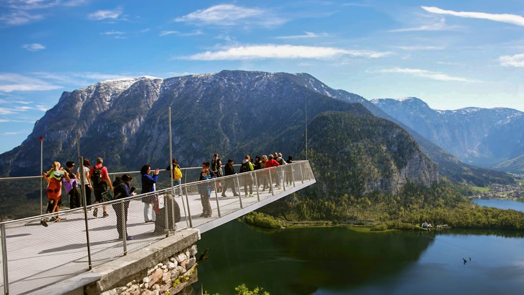 Visitors on a viewing platform overlooking Hallstatt's mountains and lake during a half-day trip from Salzburg.