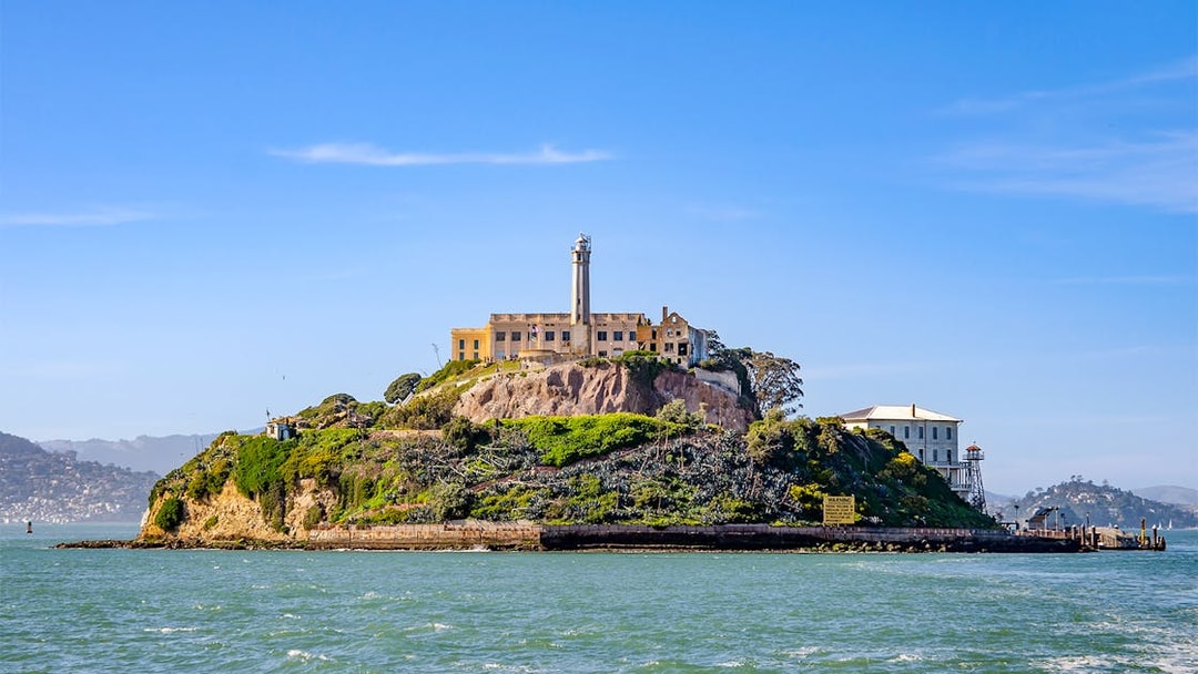 Ferry view of Alcatraz Island with historic buildings in San Francisco Bay.