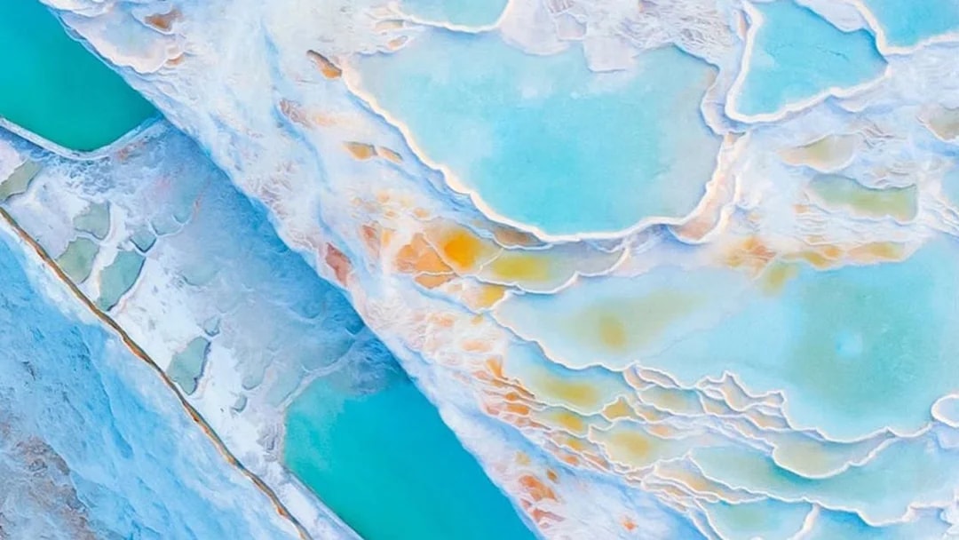 Aerial view of Pamukkale's travertine terraces with turquoise mineral-rich pools.