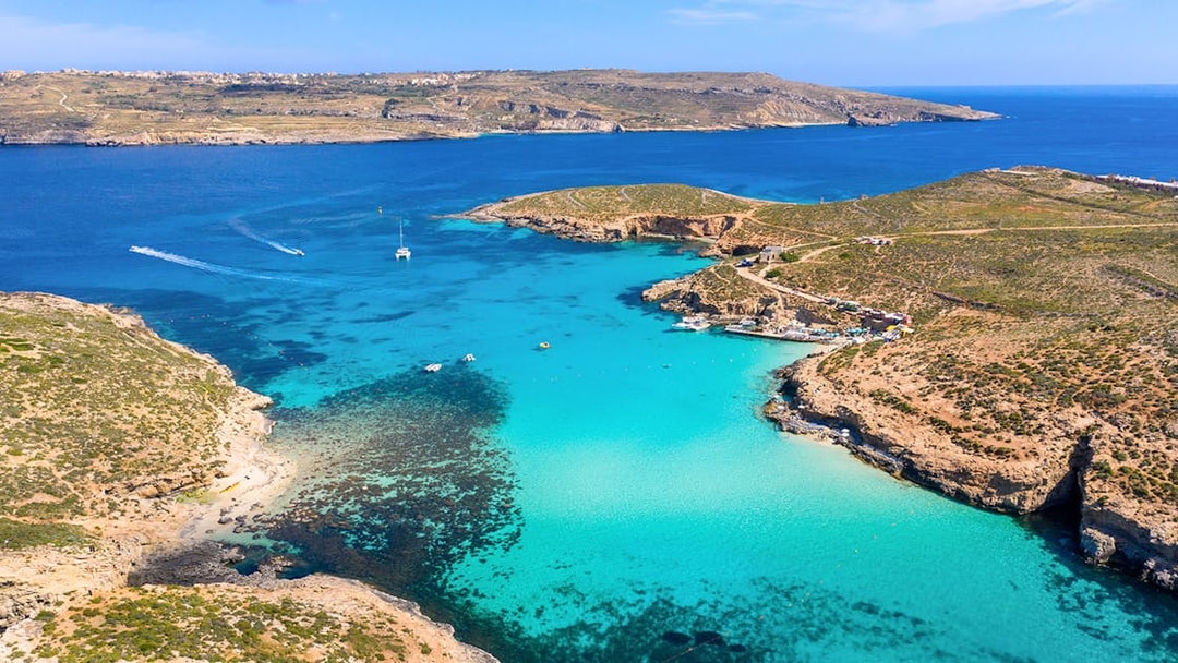 Aerial view of Blue Lagoon's turquoise waters and rocky coastline in Malta.