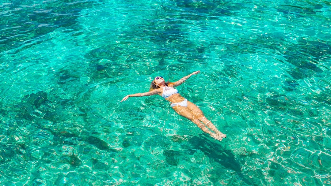 Woman swimming in clear ocean water.