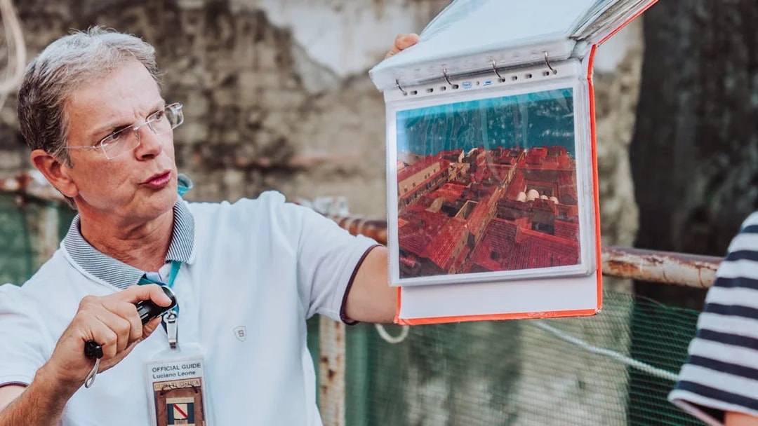 Guide showing a map of Herculaneum during a private tour.