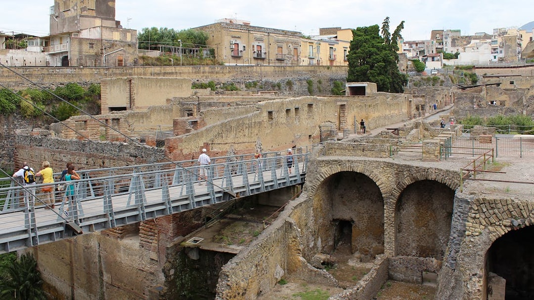 Visitors crossing a bridge towards the ancient ruins of Herculaneum, Italy.