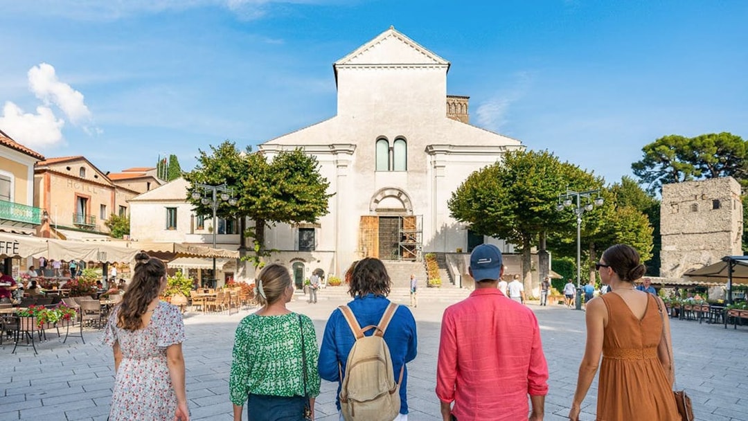 Tourists walking towards a historic church in Ravello, Italy.