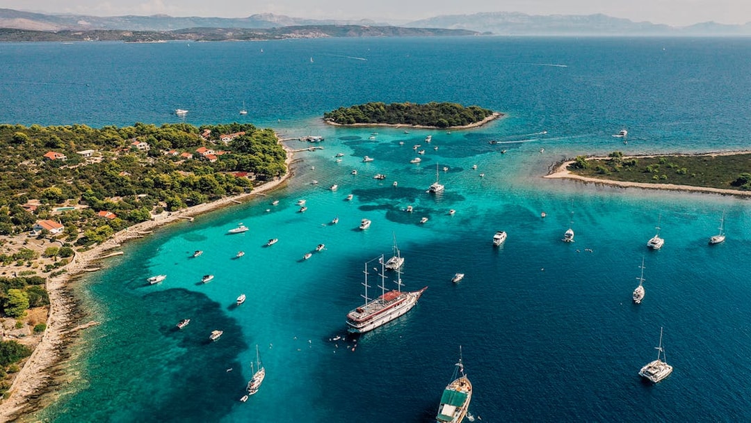 Aerial view of boats in the Blue Lagoon, Croatia, surrounded by turquoise waters and lush islands.