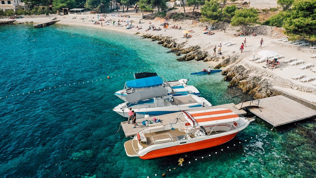 Speedboats docked at Blue Lagoon with beachgoers relaxing nearby.
