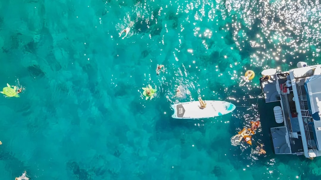 People swimming near a boat in clear blue waters during Split: Hvar & 3 islands cruise.