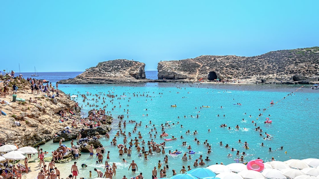 Visitors swimming and relaxing at the Blue Lagoon, Malta.