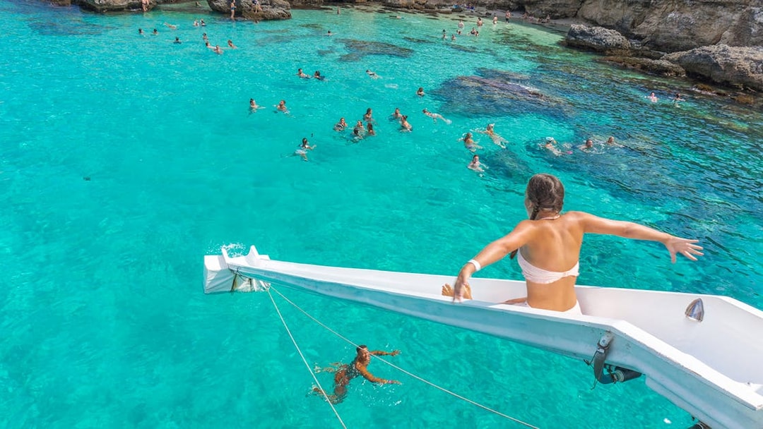 Girl sliding off cruise ship into Blue Lagoon, Malta.