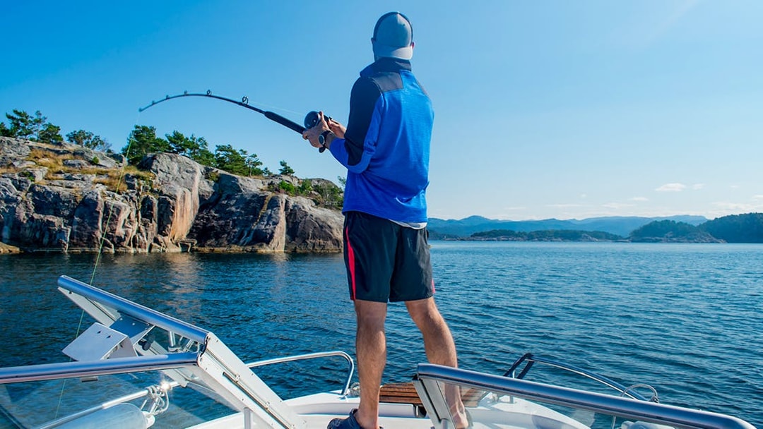 Guest fishing on a boat during Stavanger Fjord sailing trip.
