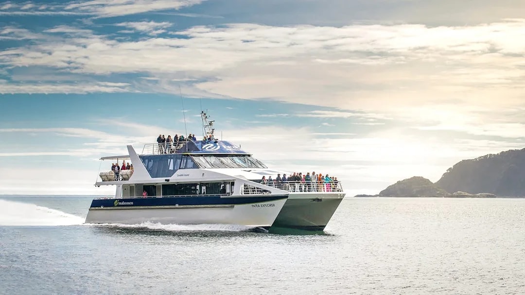 Cruise boat on Doubtful Sound with passengers enjoying scenic views, Te Anau.