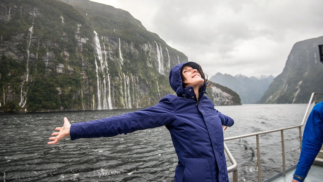 Cruise passenger enjoying scenic waterfalls on Doubtful Sound, New Zealand.