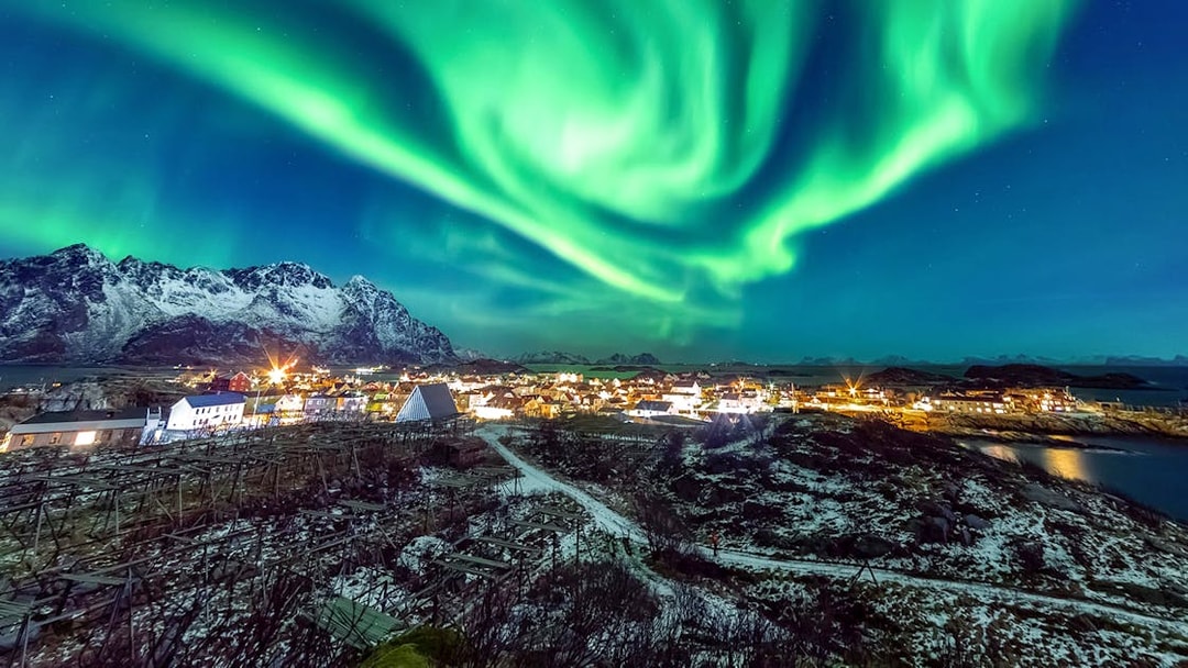 Northern Lights over snowy Tromso landscape on Northern Lights Chase Tour, Norway.
