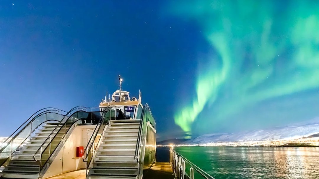 Cruise ship under Northern Lights in Tromso, Norway.