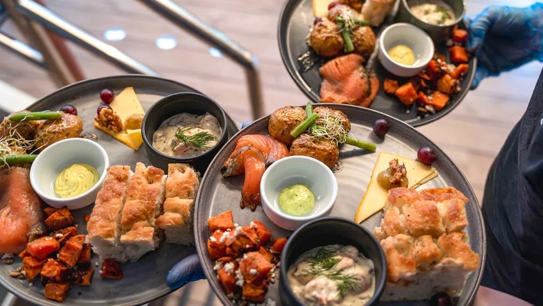 Gourmet dishes served on a dinner cruise, featuring salmon, potatoes, and bread.