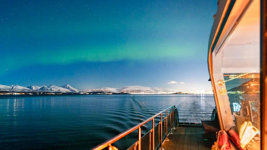 Cruise ship deck under Northern Lights near Tromso, Norway.